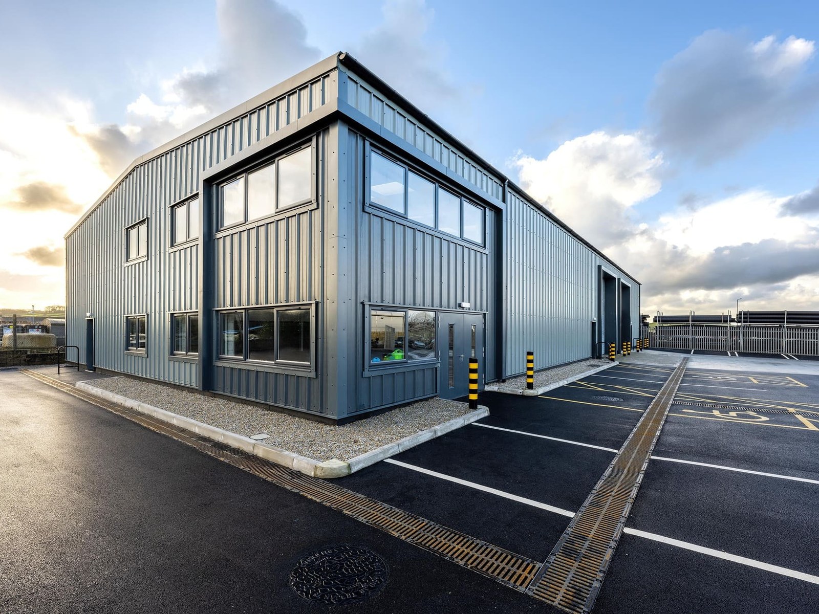 Modern commercial and industrial unit with glazed office frontage and car park